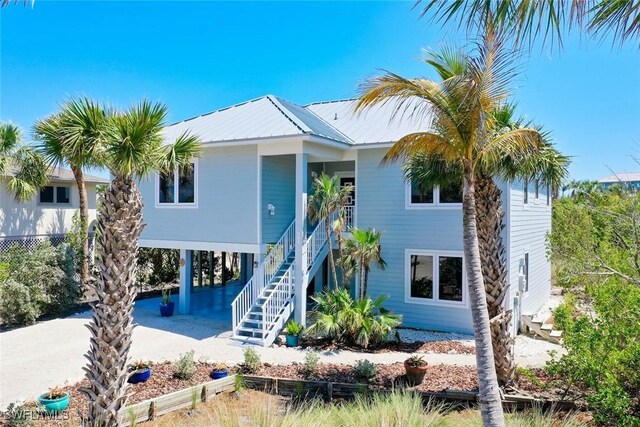 984 Black Skimmer Way, Sanibel, FL 33957 - back of house featuring metal roof, stairway, and a carport