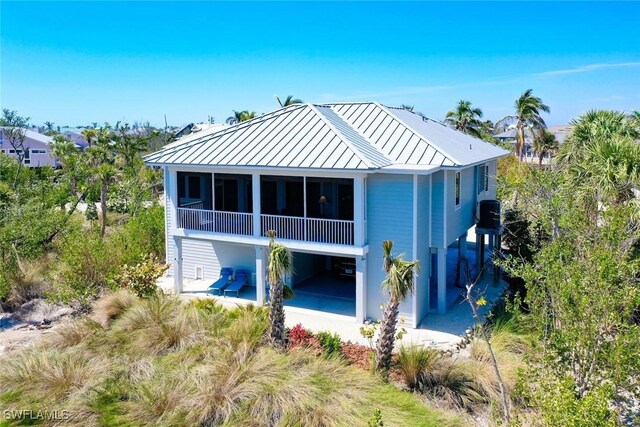 984 Black Skimmer Way, Sanibel, FL 33957 - back of property with a sunroom, a standing seam roof, and metal roof