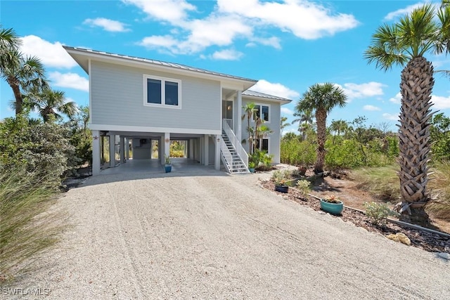 984 Black Skimmer Way, Sanibel, FL 33957 - raised beach house featuring metal roof, dirt driveway, stairway, a standing seam roof, and a carport