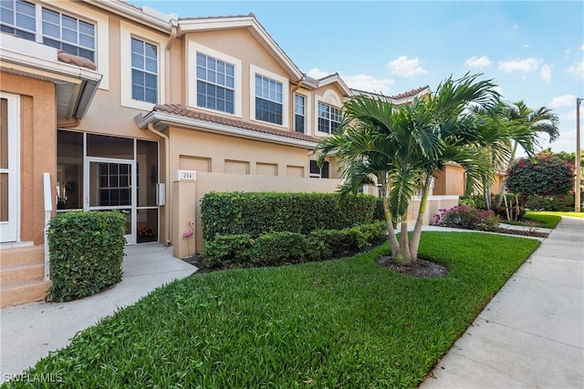 multi unit property with stucco siding, a front lawn, and entry steps