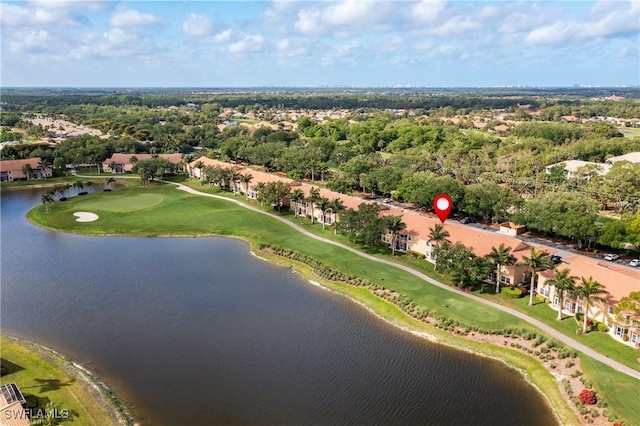 drone / aerial view of a nearby body of water, a golf course, and a tree filled landscape