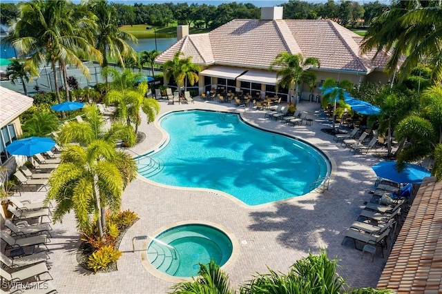 community pool with a community hot tub and a patio area