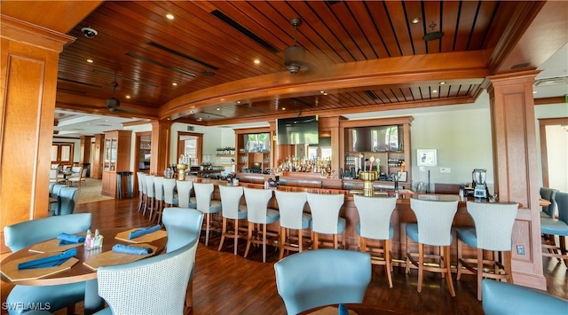 community bar area with ornate columns, wood ceiling, and wood finished floors