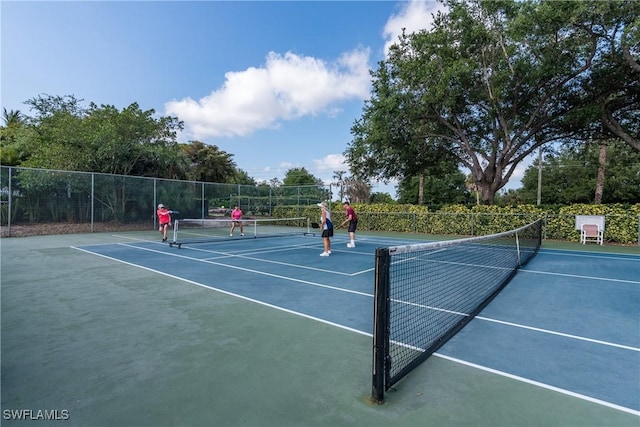 view of tennis court with fence and community basketball court