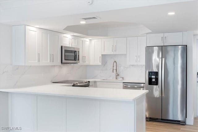 100 Estero Blvd Unit 633, Fort Myers Beach, FL 33931 - kitchen featuring appliances with stainless steel finishes, a sink, a peninsula, light countertops, and white cabinets