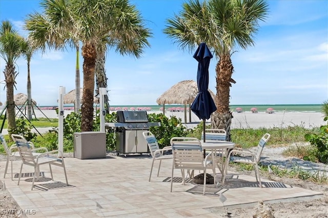 100 Estero Blvd Unit 633, Fort Myers Beach, FL 33931 - view of patio with view of water and beach, outdoor dining area, and a grill