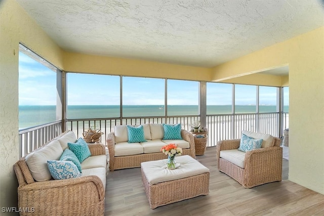 100 Estero Blvd Unit 633, Fort Myers Beach, FL 33931 - sunroom / solarium featuring a water view, a textured ceiling, wood finished floors, and a textured wall