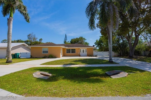 2590 Poinciana St, Naples, FL 34105 - ranch-style home featuring driveway, stucco siding, fence, and a front lawn