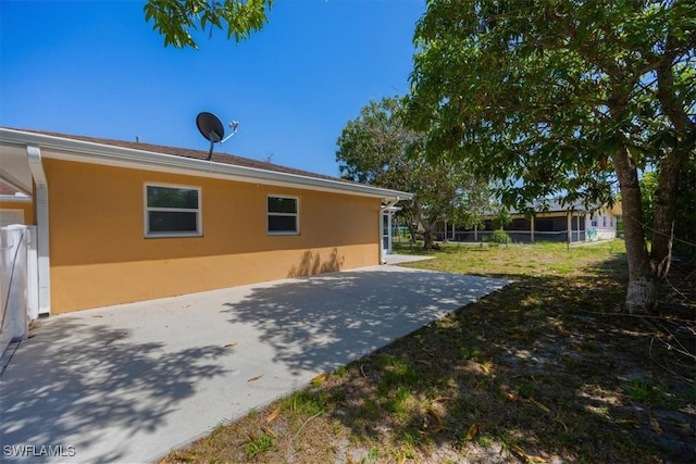 2590 Poinciana St, Naples, FL 34105 - rear view of property with a yard, a patio area, and stucco siding