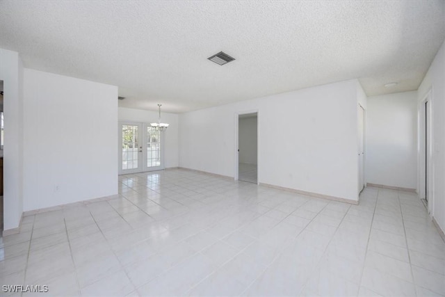 2590 Poinciana St, Naples, FL 34105 - unfurnished room with baseboards, a chandelier, light tile patterned floors, a textured ceiling, and visible vents