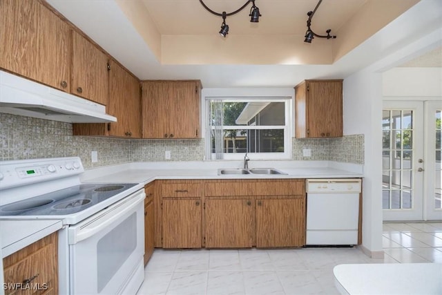 2590 Poinciana St, Naples, FL 34105 - kitchen featuring a raised ceiling, a sink, light countertops, white appliances, and backsplash