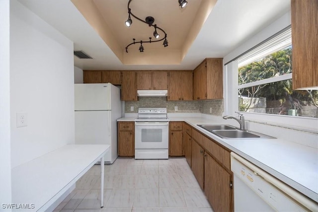 2590 Poinciana St, Naples, FL 34105 - kitchen with white appliances, tasteful backsplash, under cabinet range hood, a sink, and a raised ceiling