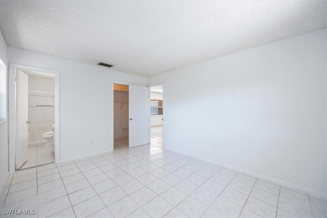 2590 Poinciana St, Naples, FL 34105 - empty room with visible vents, light tile patterned flooring, and a textured ceiling