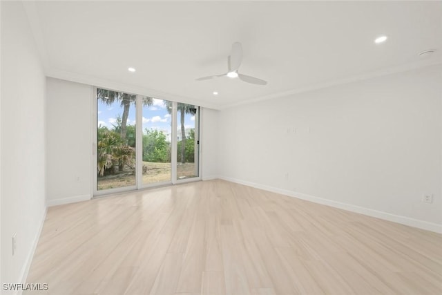 spare room featuring ceiling fan, light wood finished floors, recessed lighting, baseboards, and floor to ceiling windows