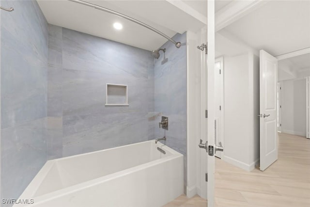 full bath with  shower combination, wood finished floors, and baseboards