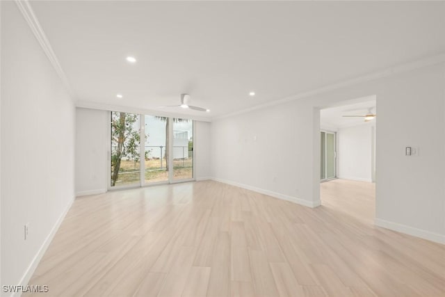 empty room featuring a ceiling fan, ornamental molding, recessed lighting, baseboards, and floor to ceiling windows