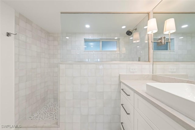 full bath with a walk in shower, tile walls, vanity, and recessed lighting