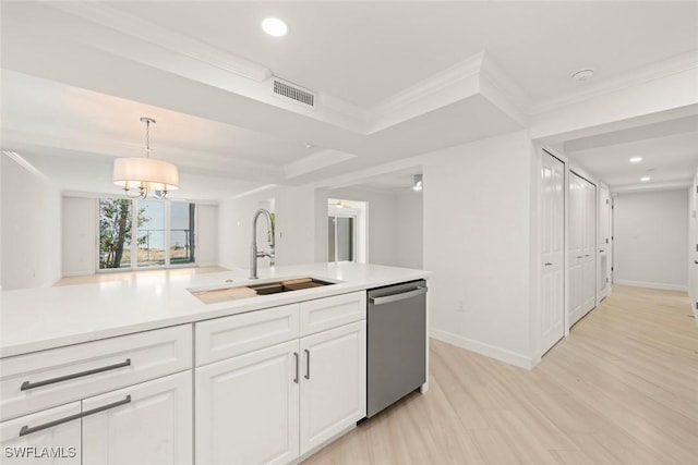 kitchen featuring stainless steel dishwasher, a sink, white cabinets, light countertops, and light wood-style flooring