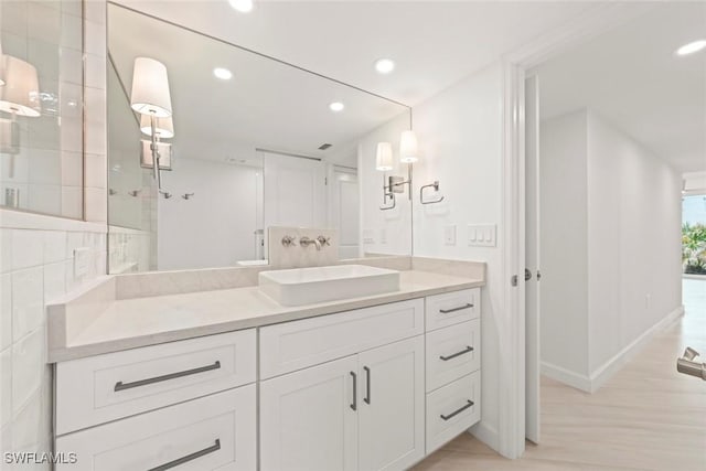 bathroom with vanity, recessed lighting, wood finished floors, baseboards, and a shower
