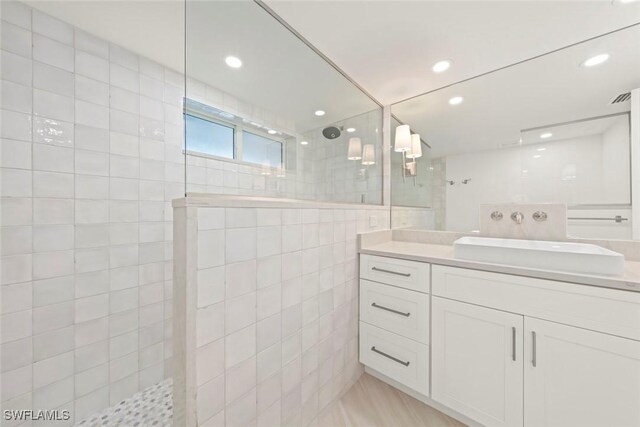 bathroom with a walk in shower, vanity, recessed lighting, and tile walls