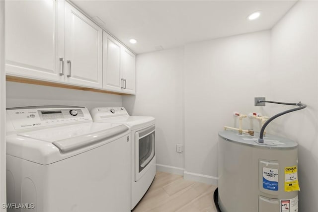 clothes washing area with cabinet space, separate washer and dryer, water heater, baseboards, and recessed lighting