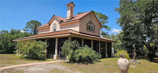 8051 Primrose Blvd, Labelle, FL 33935 - view of front of house featuring a sunroom, stucco siding, metal roof, and a front yard