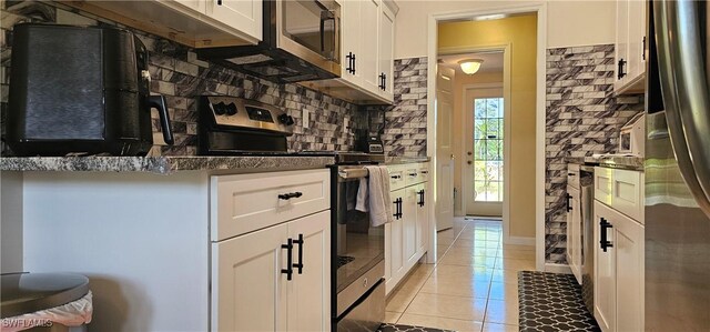 8051 Primrose Blvd, Labelle, FL 33935 - kitchen with stainless steel appliances, tasteful backsplash, light tile patterned floors, white cabinets, and dark countertops