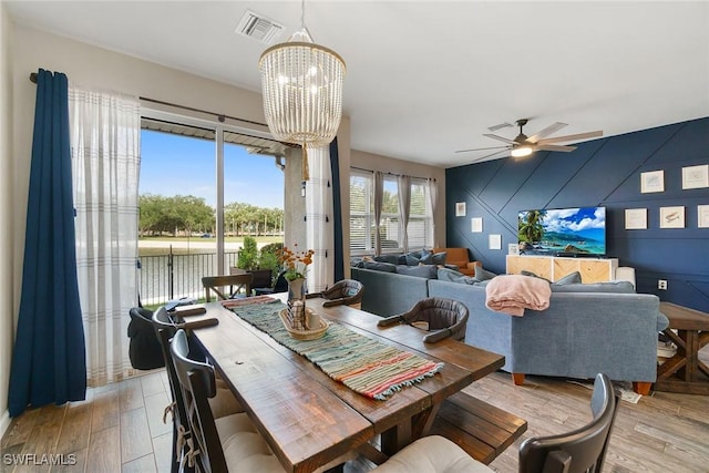 12605 Laurel Cove Dr, Fort Myers, FL 33913 - dining area with visible vents, light wood-style flooring, and ceiling fan with notable chandelier