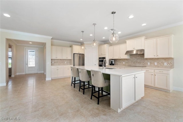 kitchen featuring light countertops, visible vents, appliances with stainless steel finishes, under cabinet range hood, and a spacious island