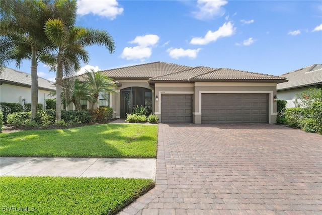 view of front of house featuring decorative driveway, a tiled roof, stucco siding, and an attached garage