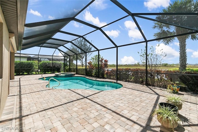 view of pool featuring glass enclosure, a pool with connected hot tub, and a patio area