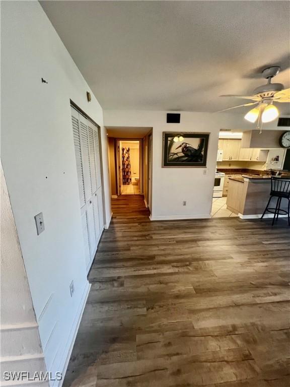 5765 Trailwinds Dr Unit 115, Fort Myers, FL 33907 - unfurnished living room featuring dark wood-style flooring, ceiling fan, and baseboards
