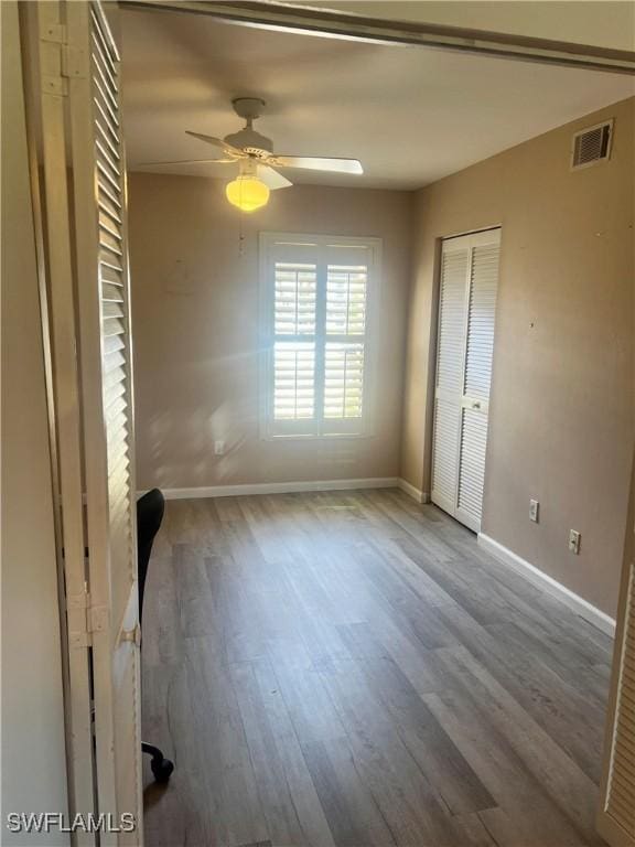 5765 Trailwinds Dr Unit 115, Fort Myers, FL 33907 - unfurnished bedroom featuring wood finished floors, baseboards, a closet, and a ceiling fan