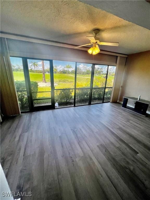 5765 Trailwinds Dr Unit 115, Fort Myers, FL 33907 - unfurnished living room featuring a textured ceiling, wood finished floors, a ceiling fan, and healthy amount of natural light