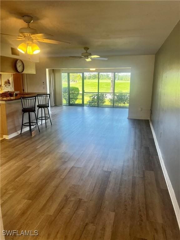 5765 Trailwinds Dr Unit 115, Fort Myers, FL 33907 - living area with plenty of natural light, wood finished floors, baseboards, and ceiling fan