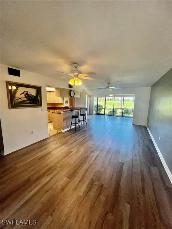 5765 Trailwinds Dr Unit 115, Fort Myers, FL 33907 - unfurnished living room with a ceiling fan, wood finished floors, and baseboards