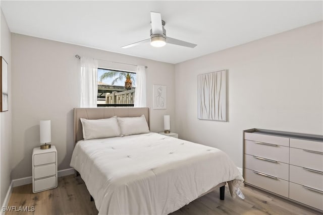 bedroom with baseboards, wood finished floors, and ceiling fan