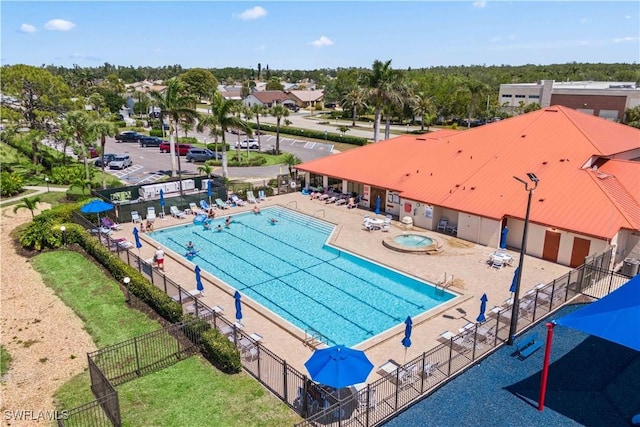 community pool with a patio and fence
