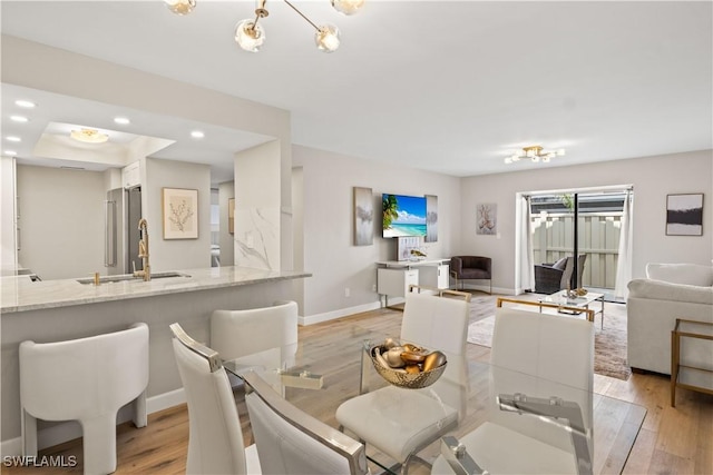 dining room featuring baseboards, light wood-style floors, and recessed lighting