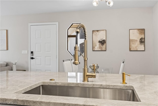 interior details with light stone countertops and a sink