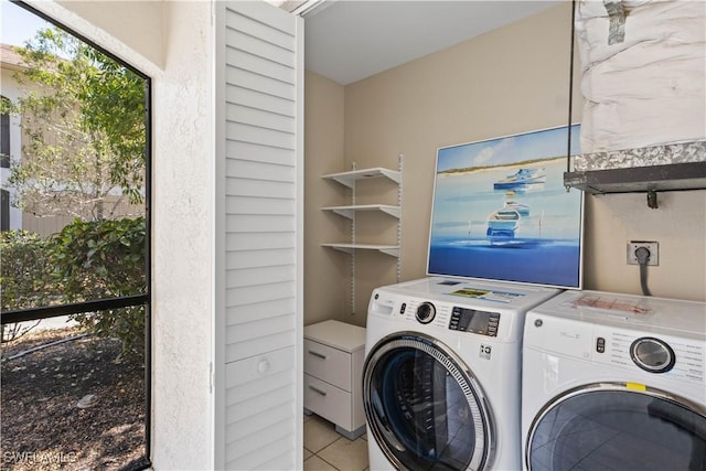 clothes washing area featuring independent washer and dryer, laundry area, and tile patterned flooring