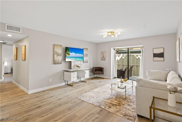 living room with light wood finished floors, baseboards, visible vents, and an inviting chandelier