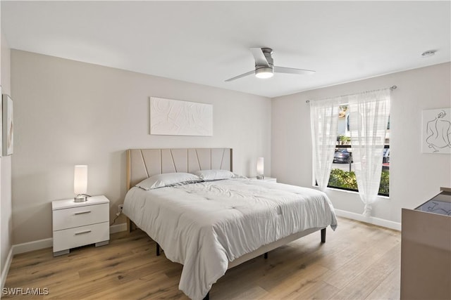 bedroom featuring a ceiling fan, baseboards, and light wood finished floors