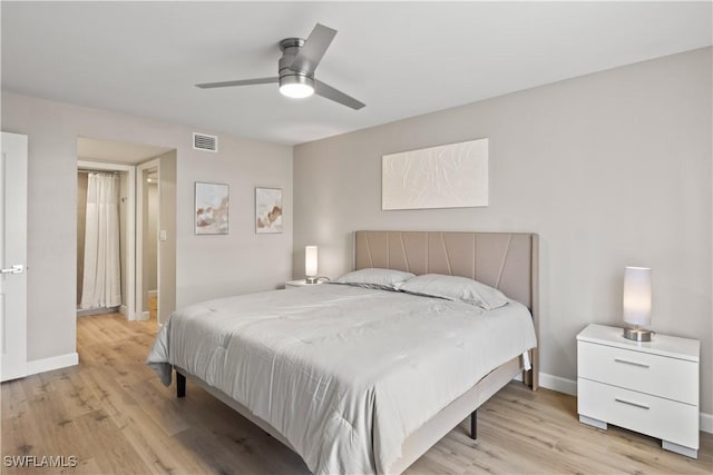 bedroom with baseboards, light wood finished floors, and visible vents