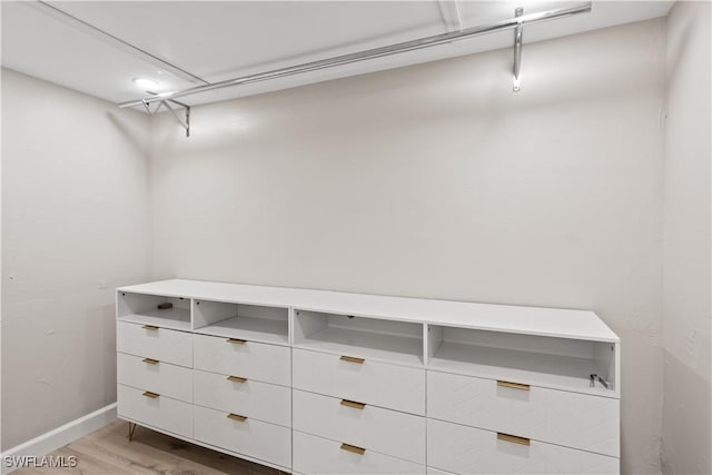 walk in closet with wood finished floors