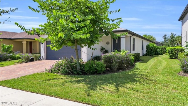 4558 Lamaida Ln, Ave Maria, FL 34142 - view of side of home featuring a garage, decorative driveway, stucco siding, and a lawn
