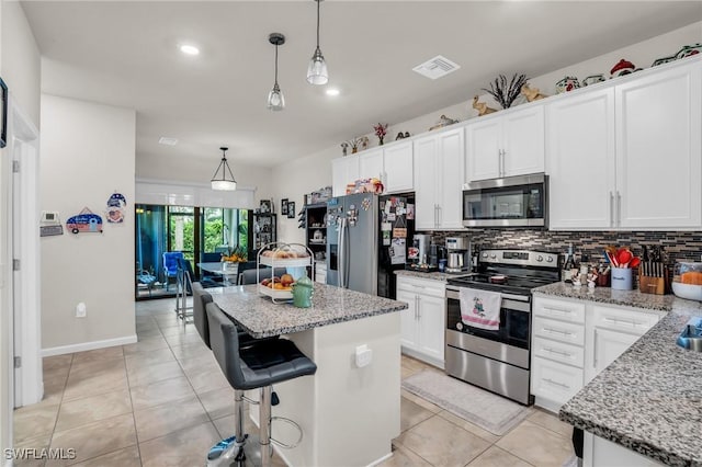 4558 Lamaida Ln, Ave Maria, FL 34142 - kitchen featuring backsplash, a kitchen island, appliances with stainless steel finishes, light tile patterned floors, and visible vents