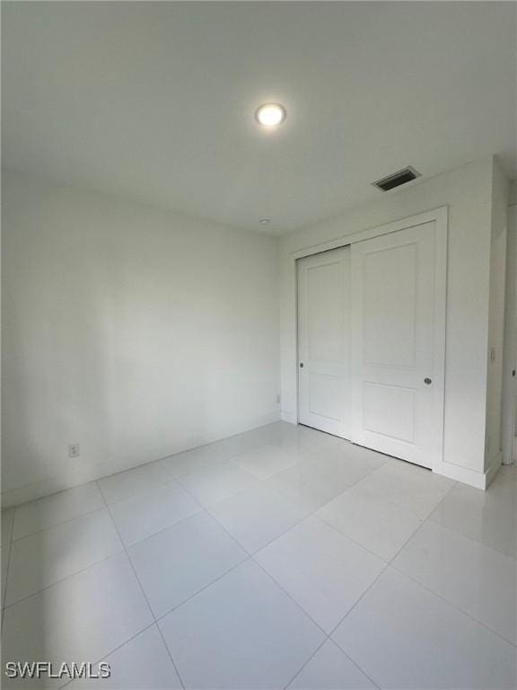 718 Chattman St E, Lehigh Acres, FL 33974 - unfurnished bedroom featuring tile patterned flooring, a closet, and recessed lighting