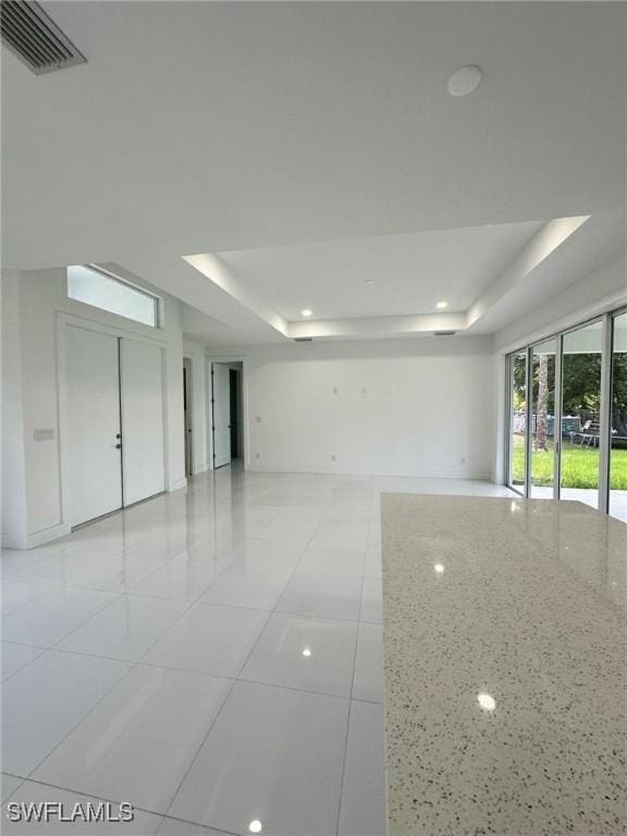 718 Chattman St E, Lehigh Acres, FL 33974 - empty room featuring a raised ceiling and light tile patterned floors