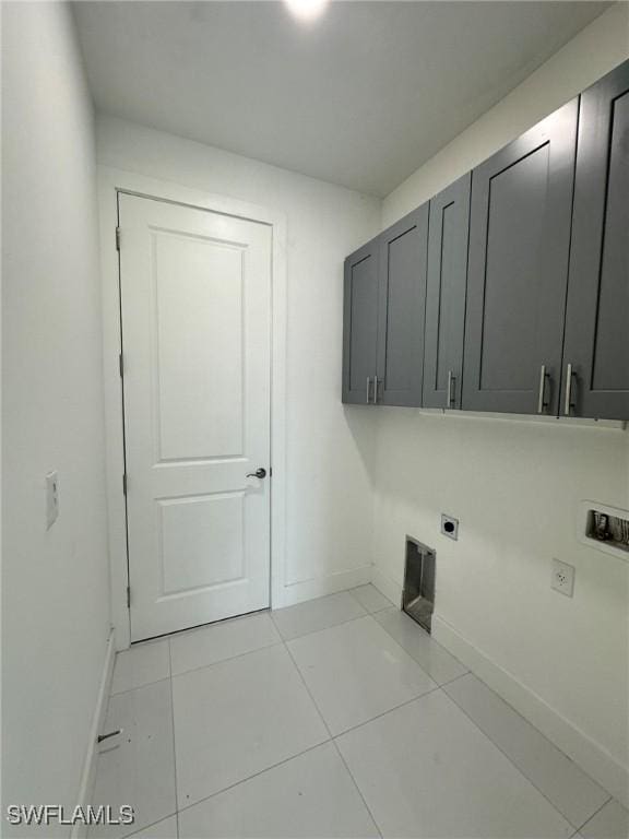 718 Chattman St E, Lehigh Acres, FL 33974 - clothes washing area featuring electric dryer hookup, cabinet space, baseboards, and light tile patterned flooring